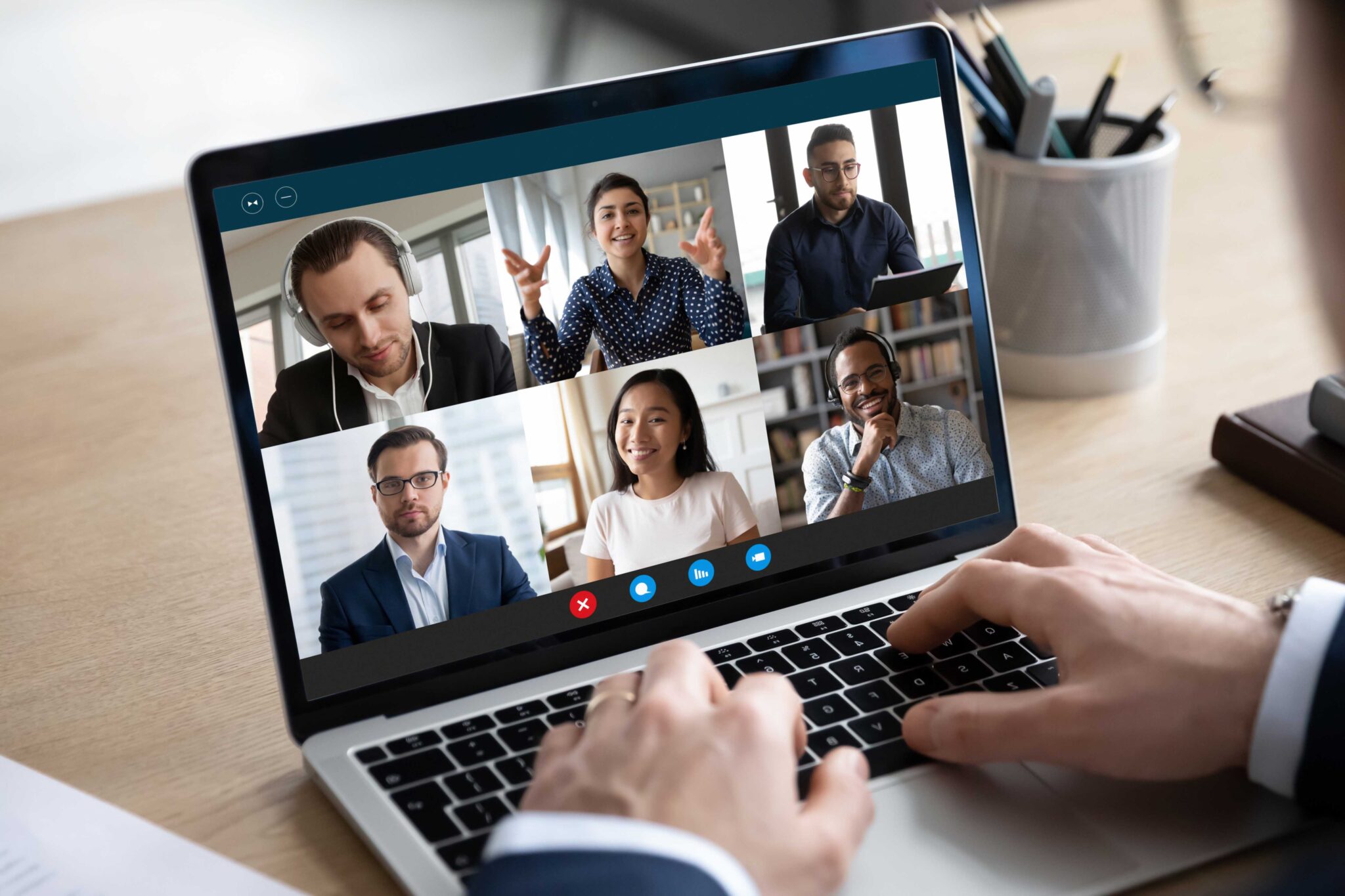 lose up focus on computer screen with happy multiracial colleagues holding online video conference call, discussing working issues remotely using computer application, distant communication concept